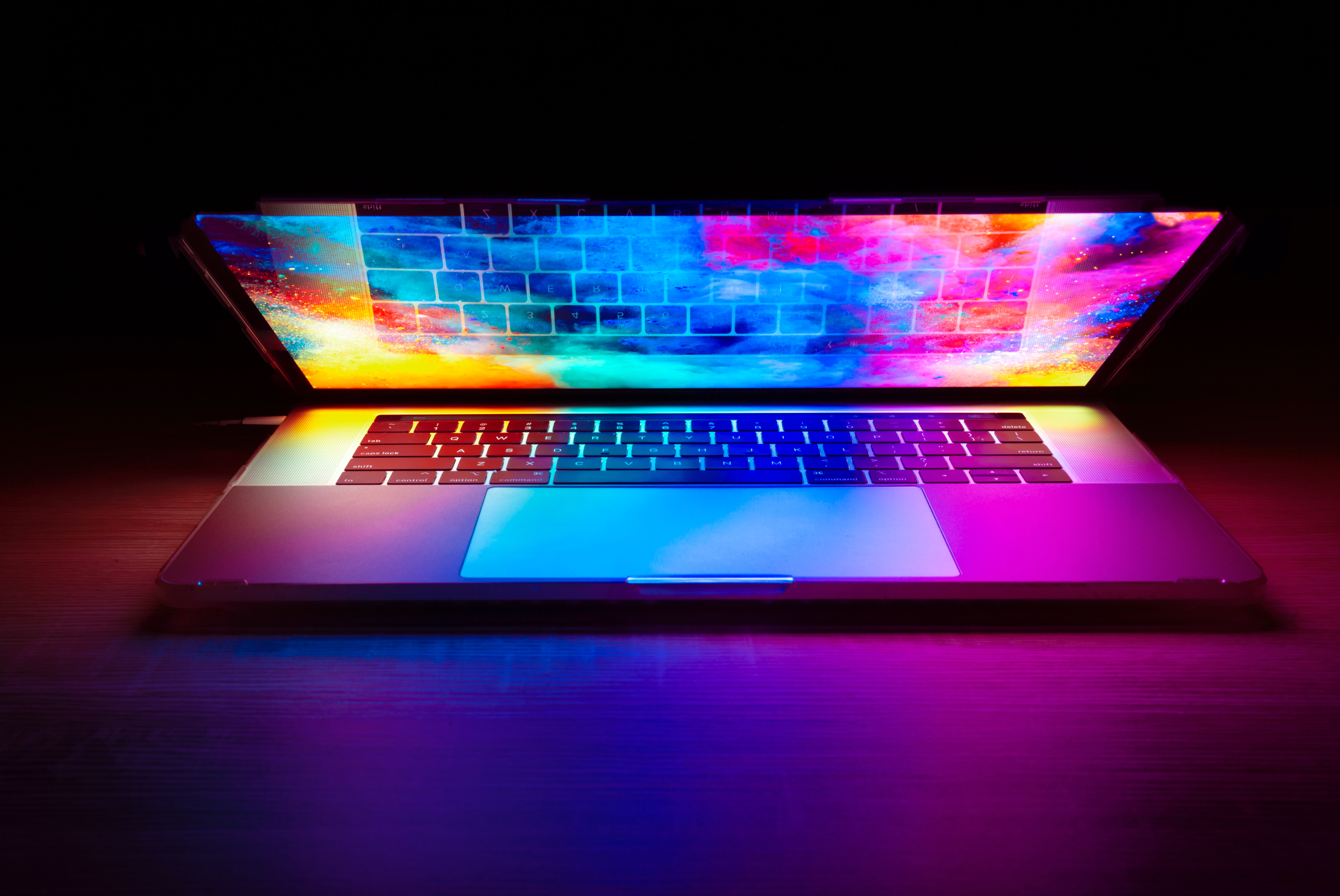 Photo of a laptop with brightly coloured ambient clouds on the screen